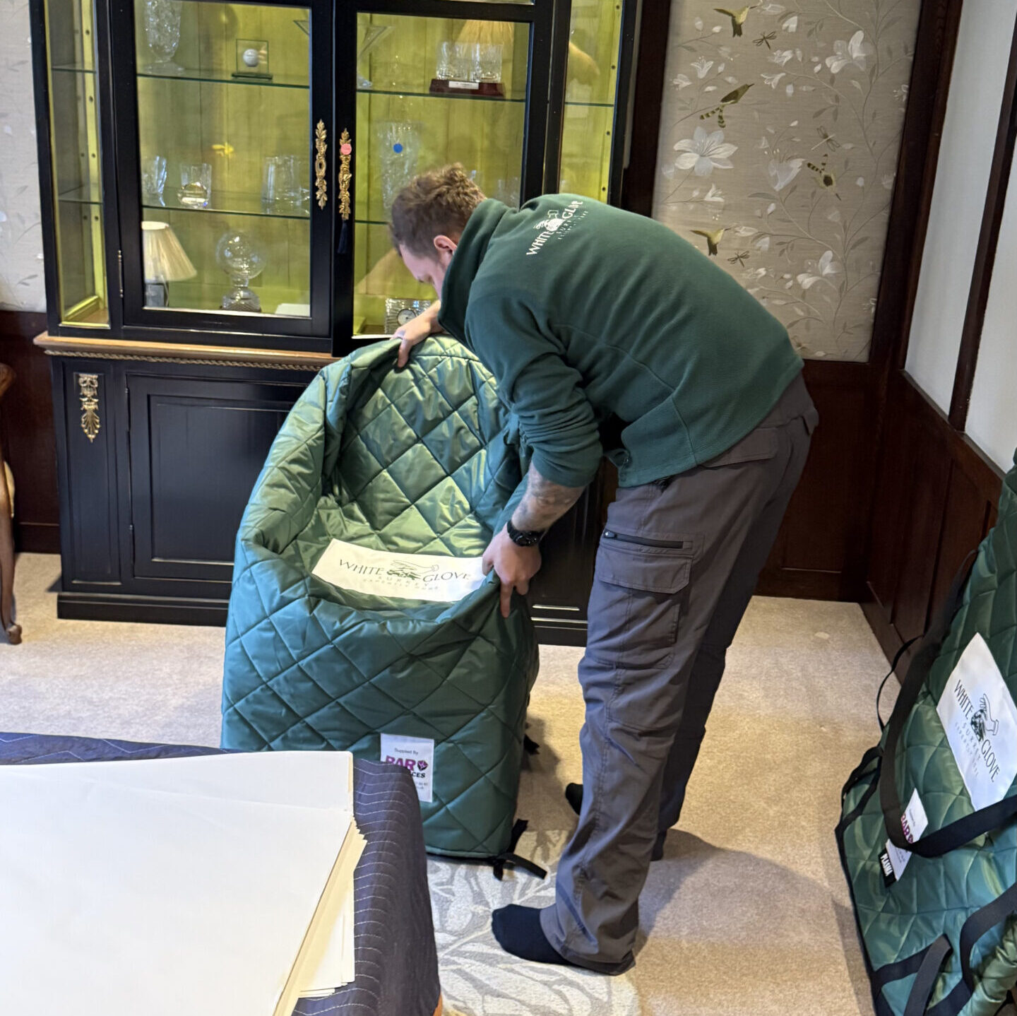 White Glove Surrey mover placing a chair in a padded cover