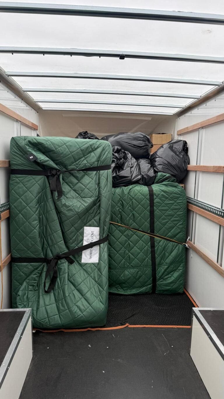 Furniture wrapped in White Glove Surrey protective covers, loaded and strapped inside a removals lorry